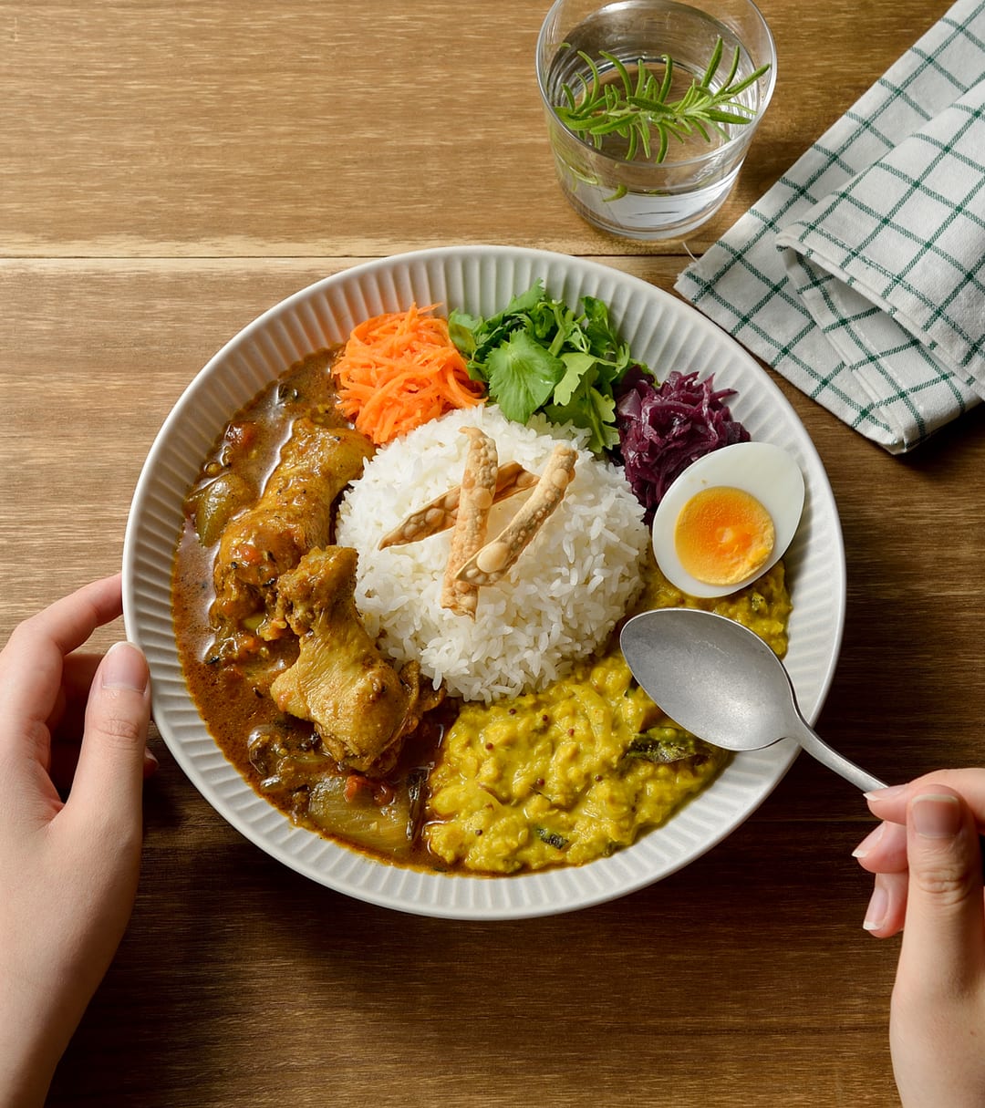 木のテーブルに置かれたスパイスカレーの俯瞰